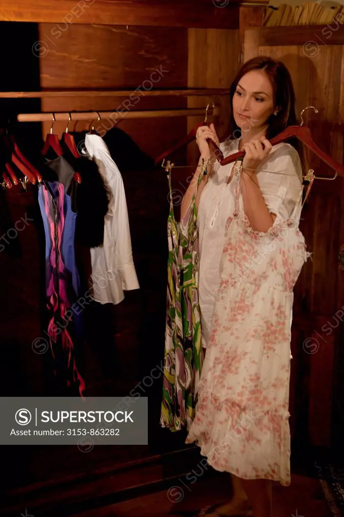 woman chooses a dress from the wardrobe