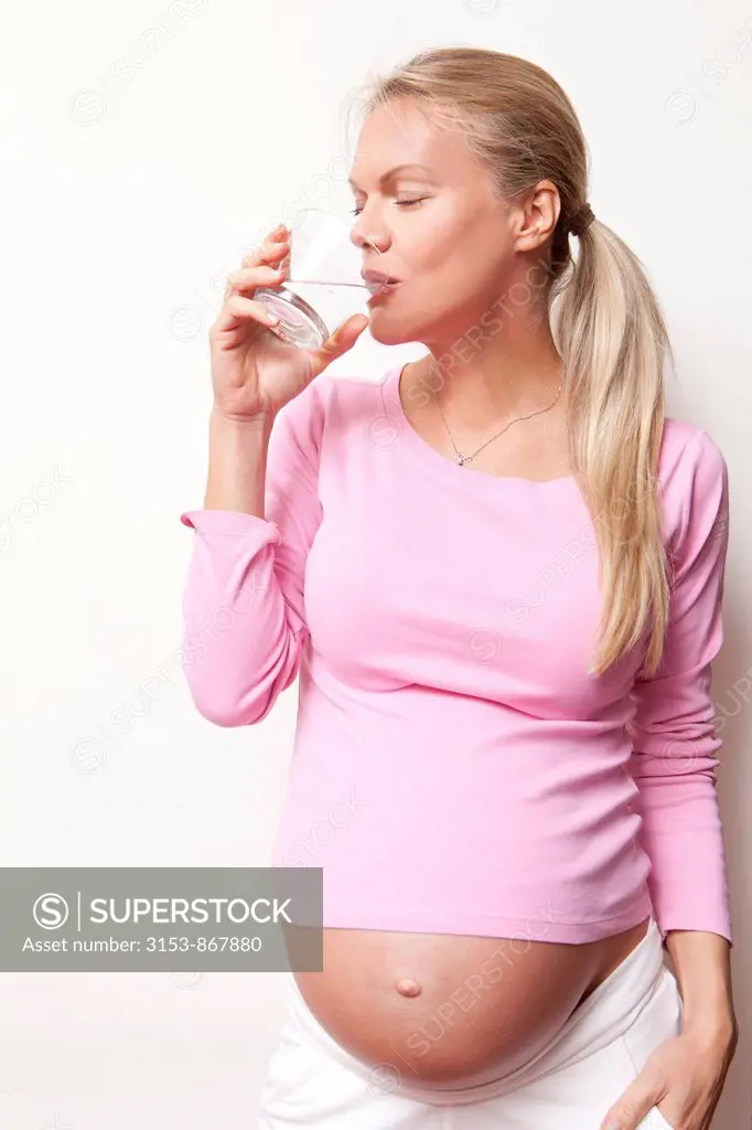 donna incinta beve un bicchier d´acqua
