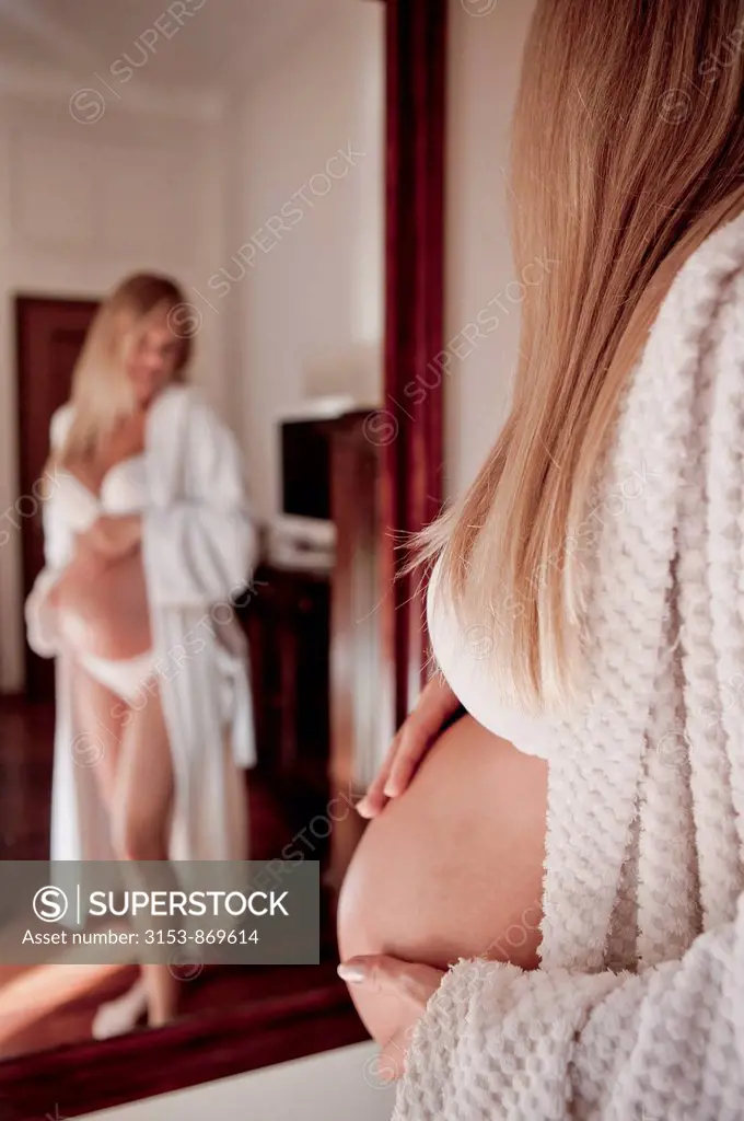 donna incinta si guarda allo specchio