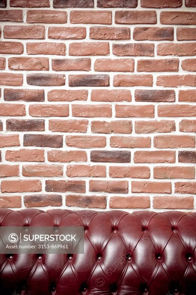 muro di mattoni e divano in pelle