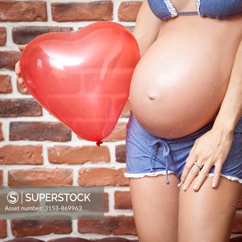 donna incinta con palloncino a forma di cuore