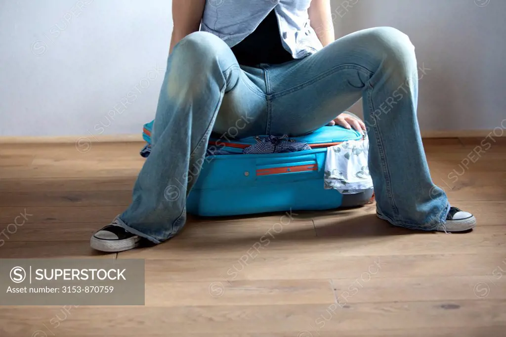 donna seduta sulla valigia