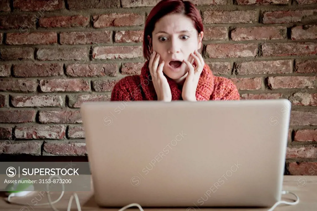 distraught woman looking the laptop