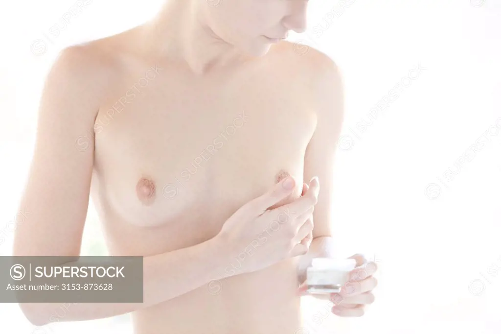 woman applying lotion on her breast