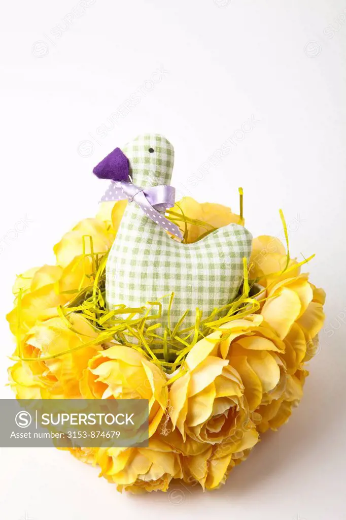 duck stuffed in a basket of yellow roses