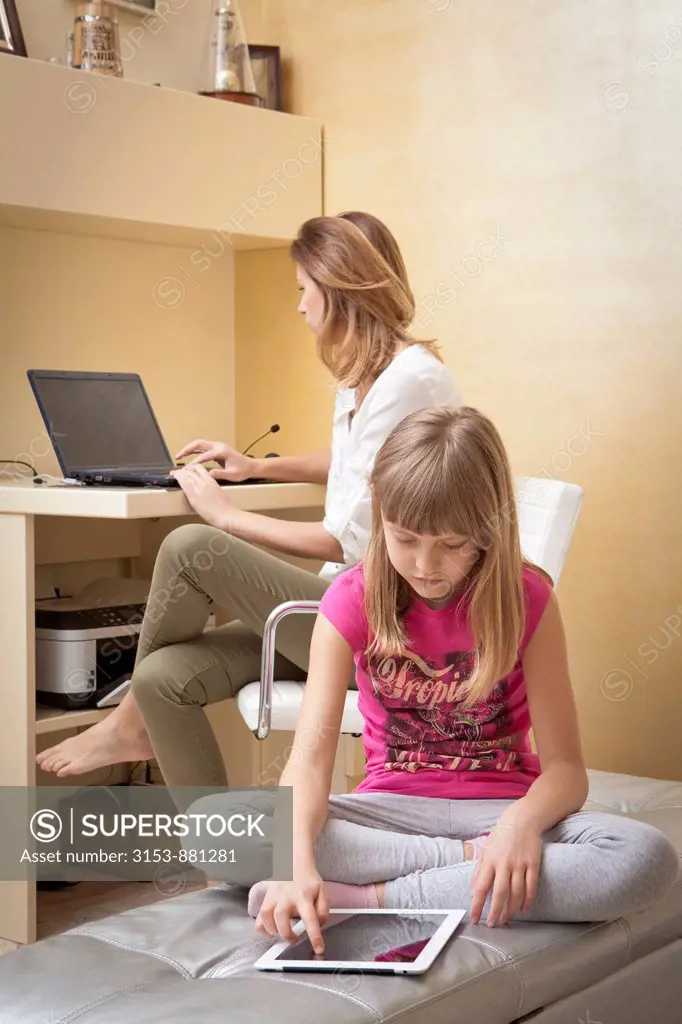 mother and daughter with ipad and laptop