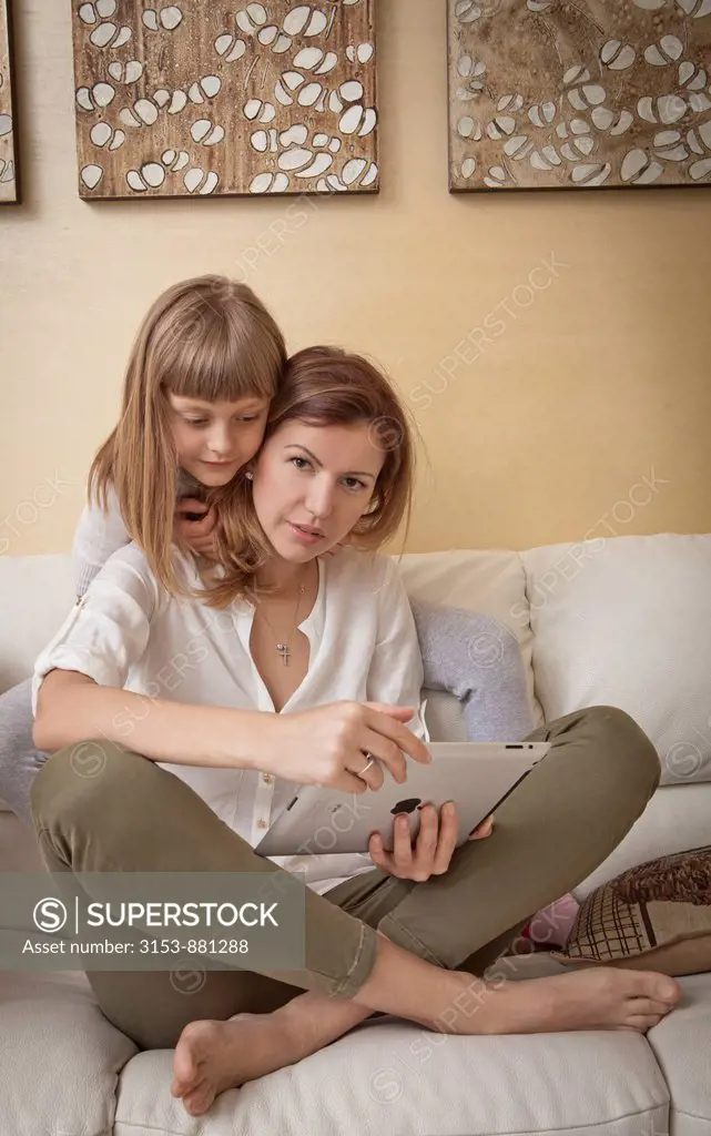 mother and daughter on couch with iPad