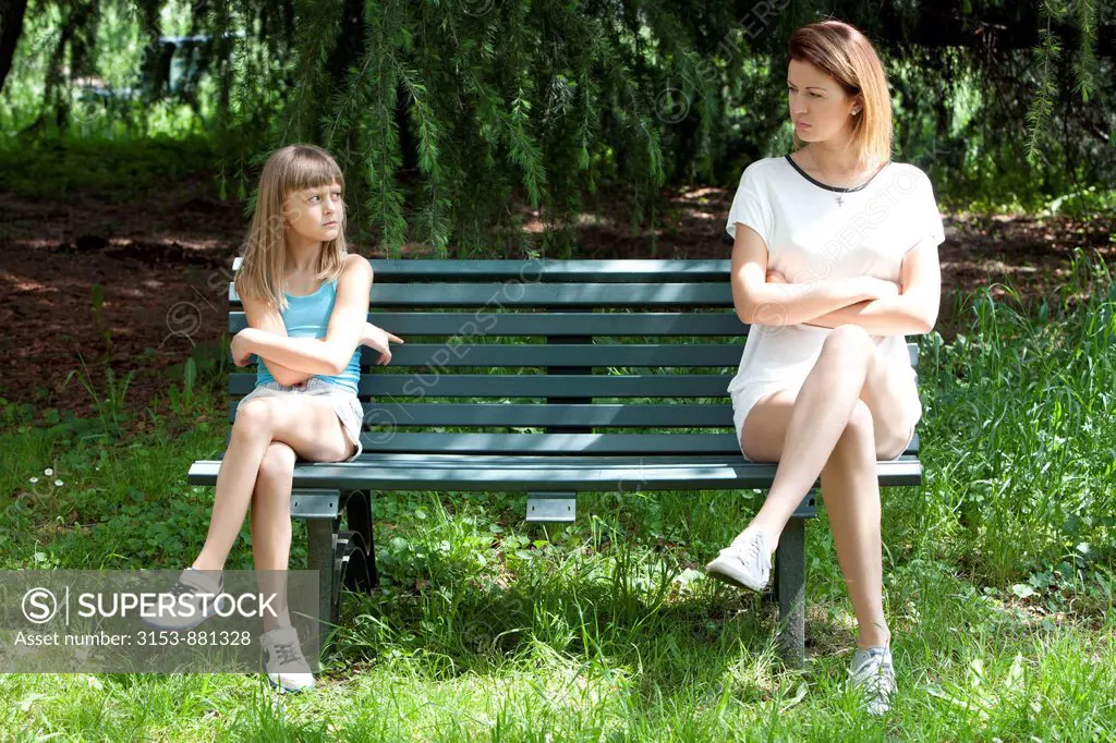 mother and daughter sitting on a bench