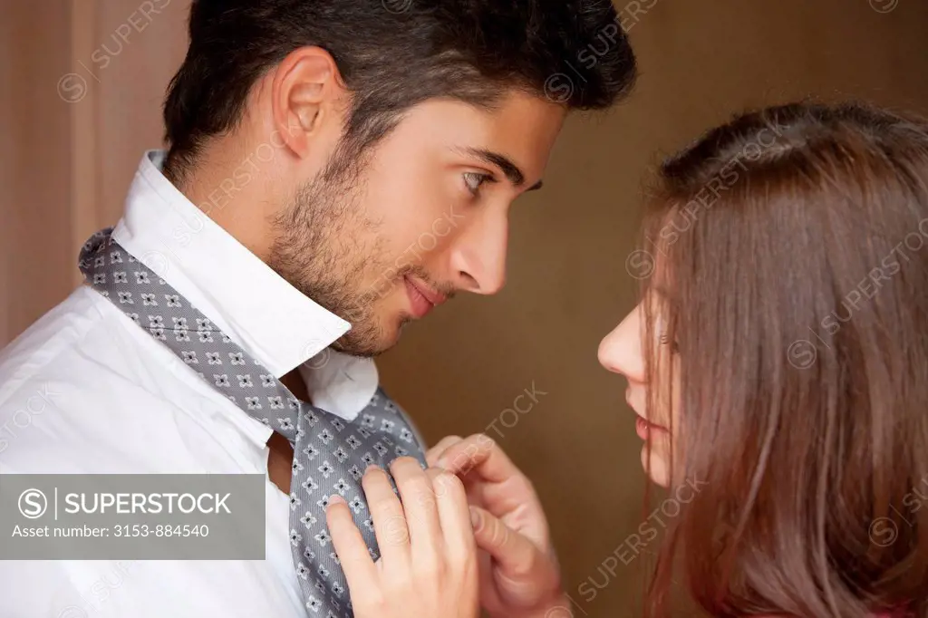 couple, woman knotting his tie