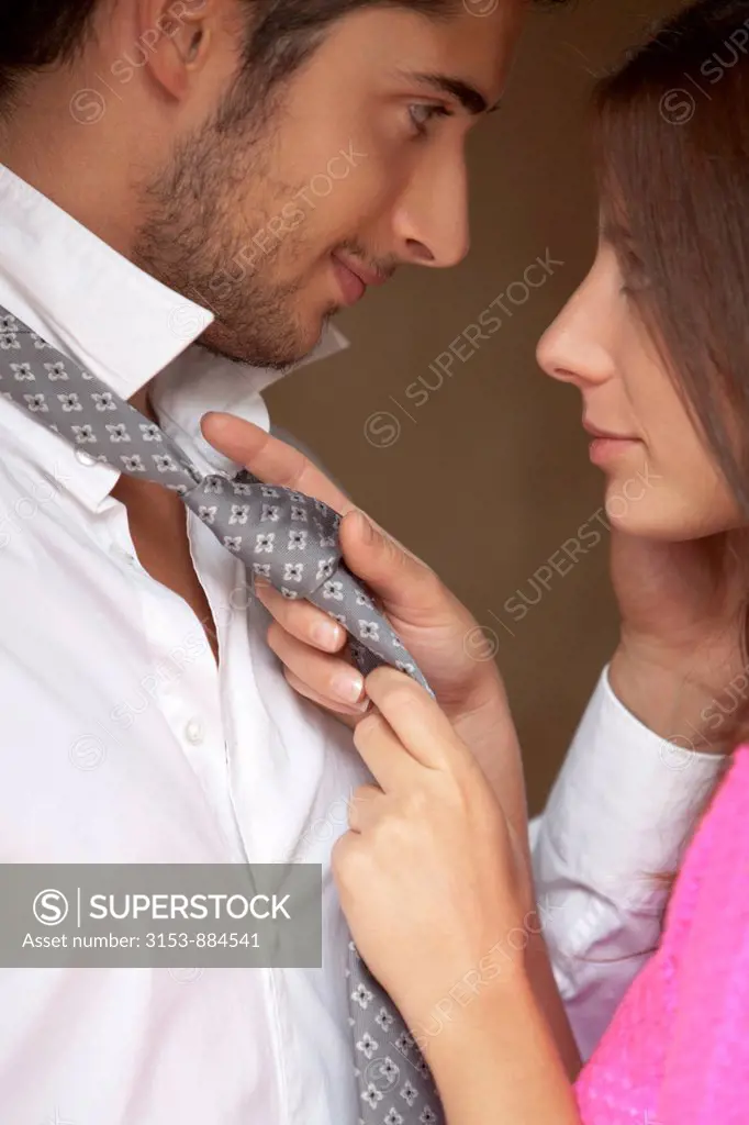 couple, woman knotting his tie
