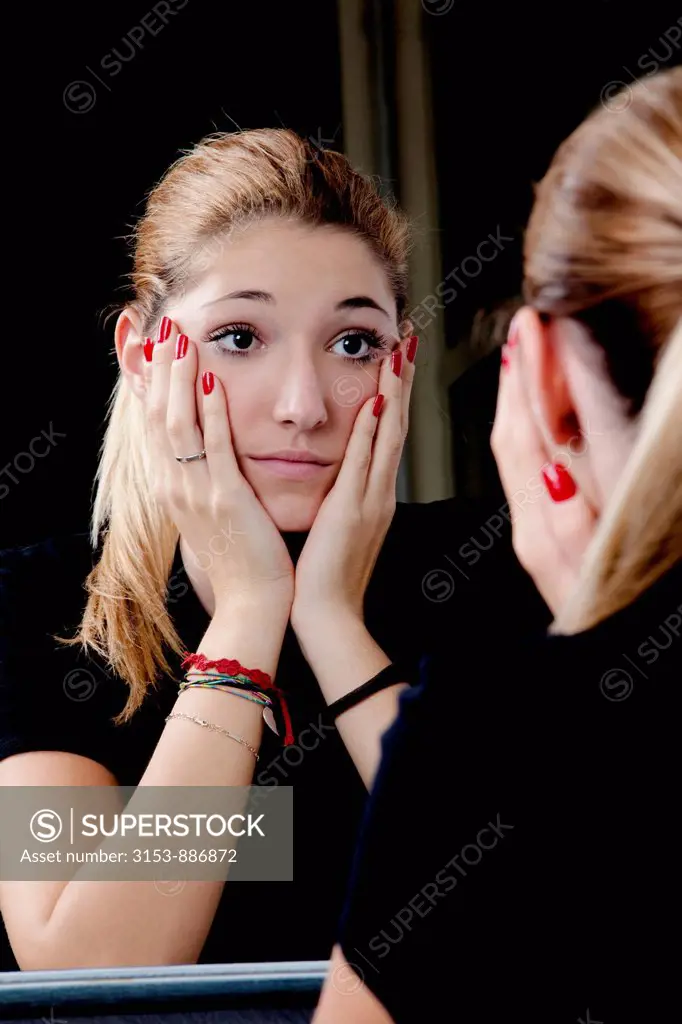 teenage girl looking at the mirror