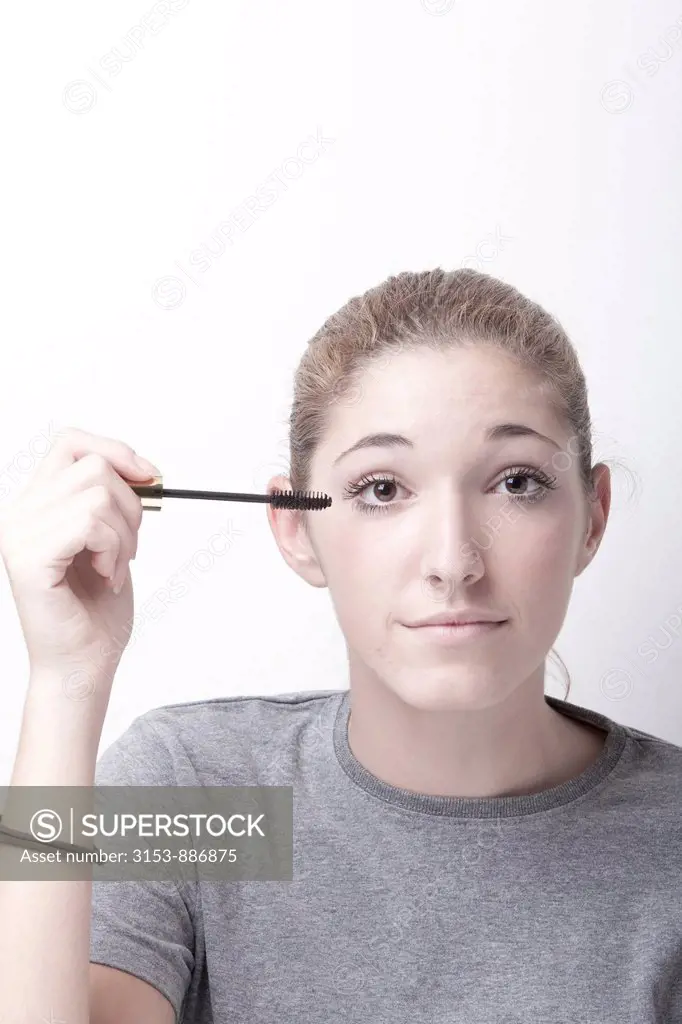 teenage girl applying mascara