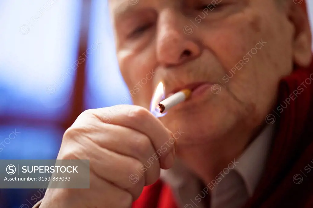 elderly man lighting a cigarette