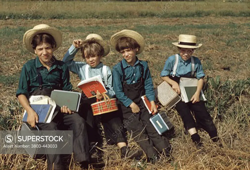 Children sitting with their books in a field, Amish Country, Pennsylvania, USA