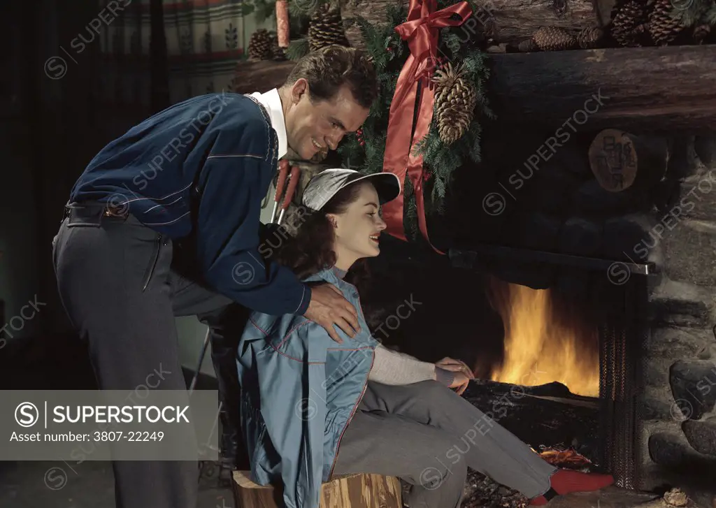 Young couple sitting near a fireplace