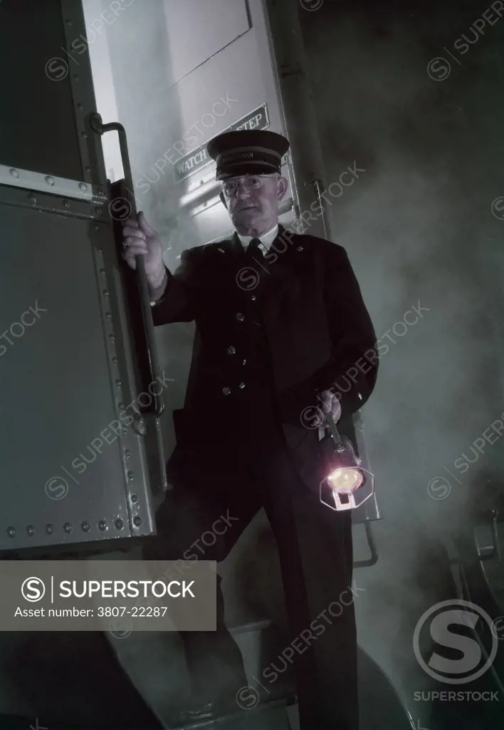 Train conductor standing on the steps of a train coach