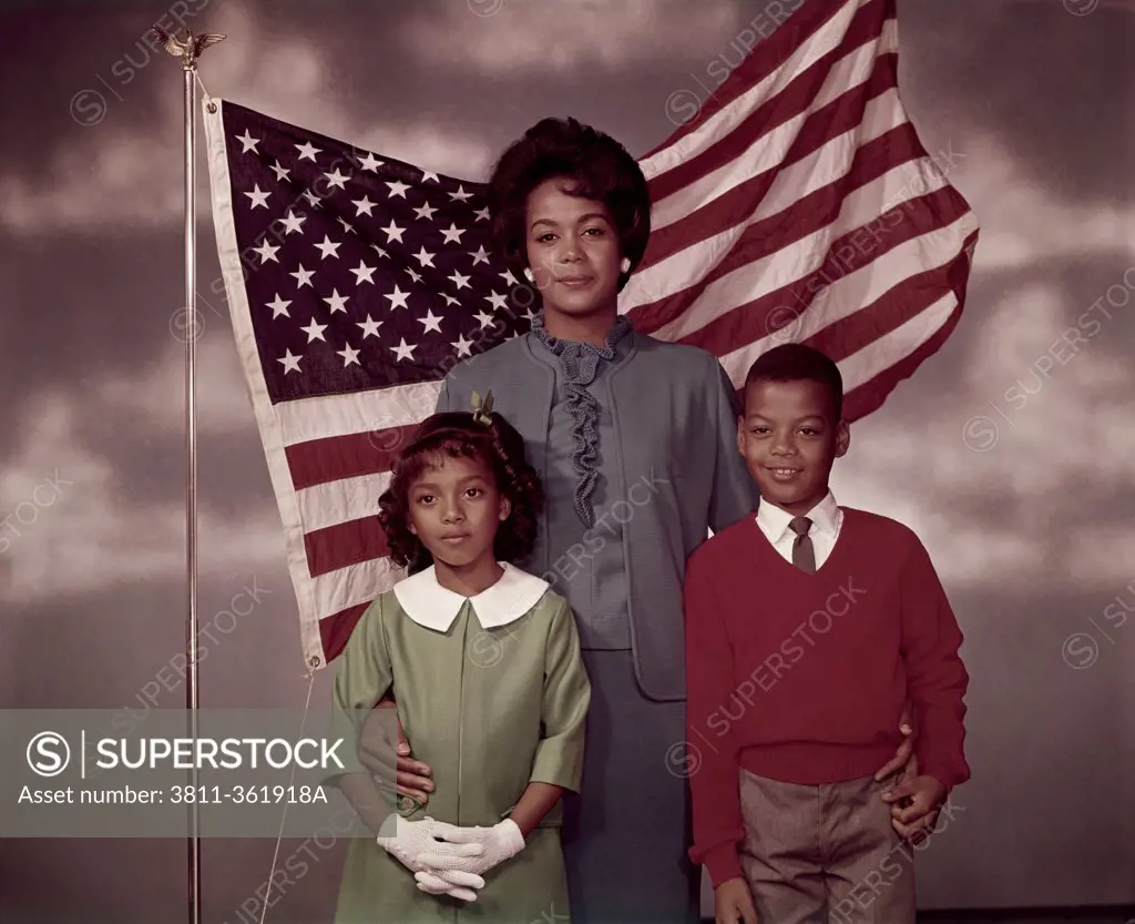 Family standing in front of an American flag