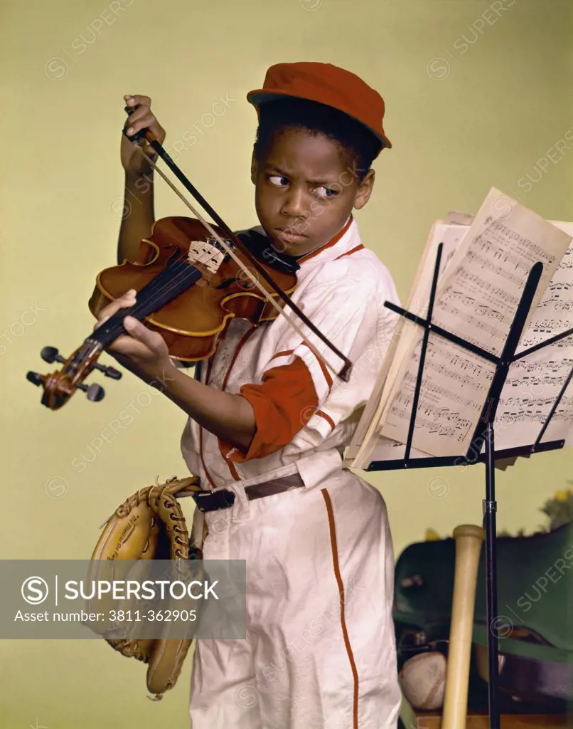 Close-up of a boy looking at a musical stand and playing a violin