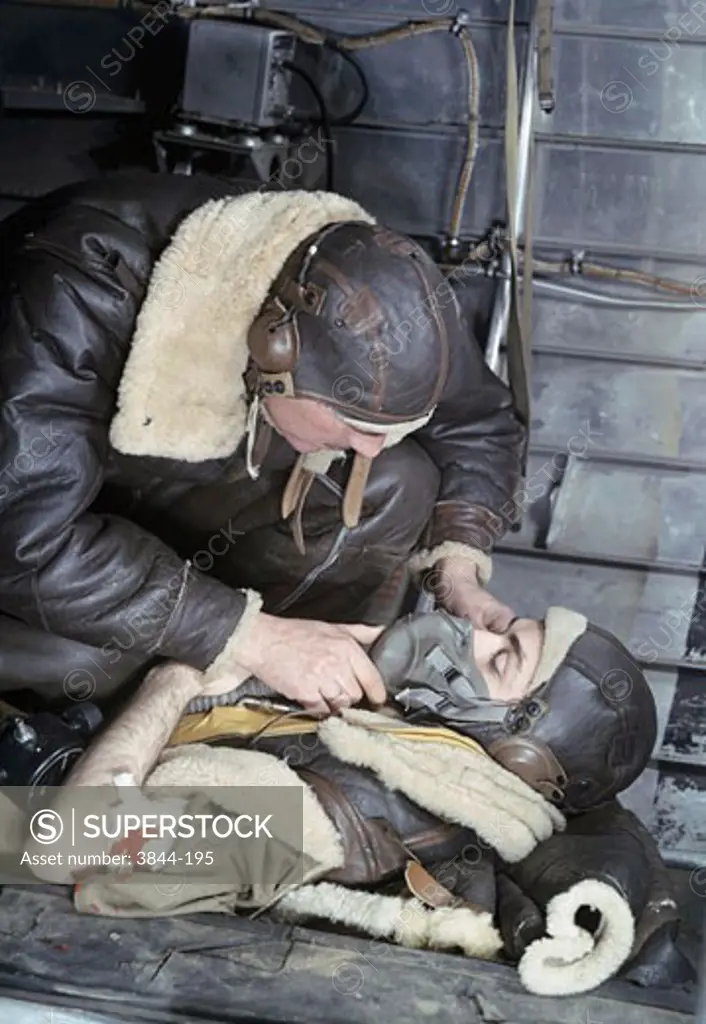 Close-up of a soldier putting an oxygen mask to an injured soldier's face