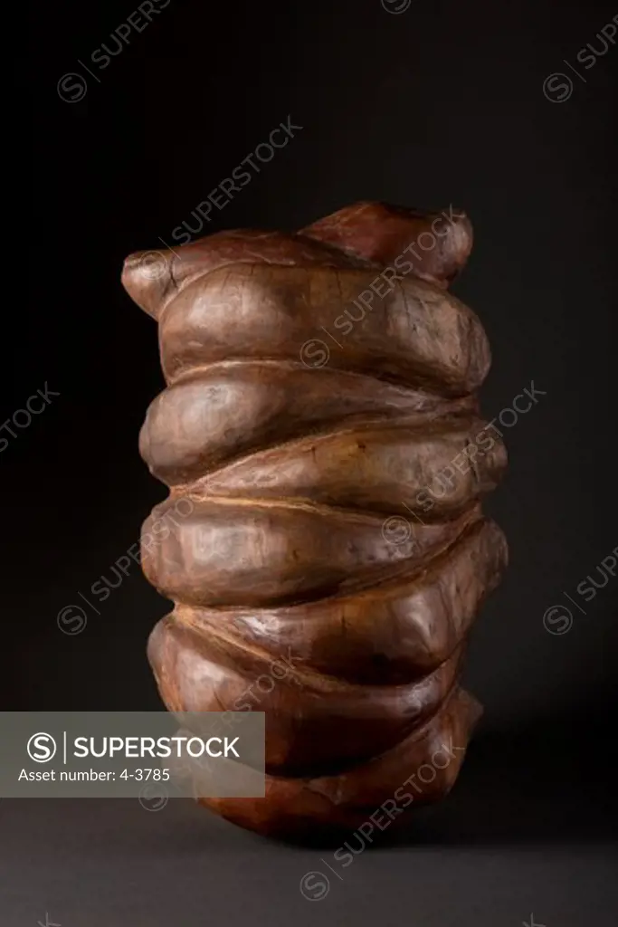 Wooden sculpture of clasped hands on black background
