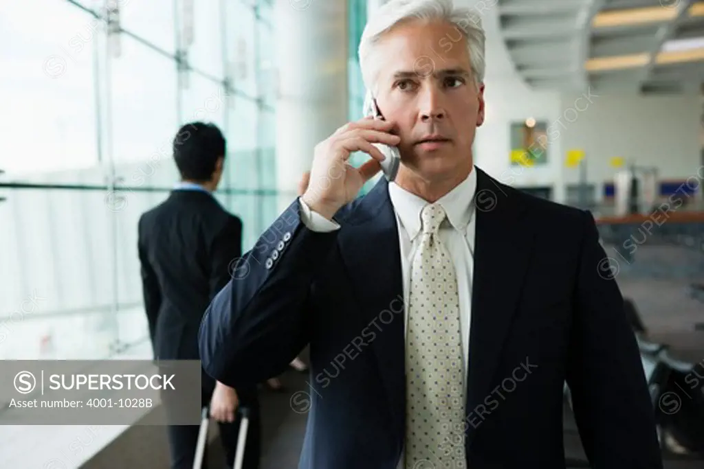 Businessman talking on cell phone at the airport