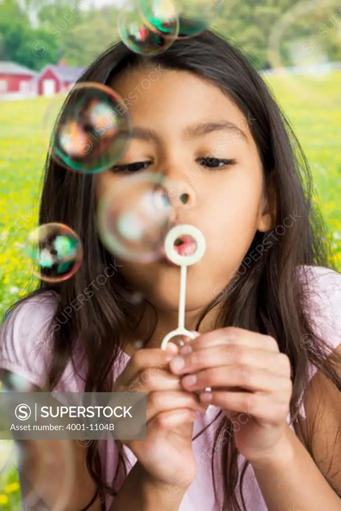 Close-up of a girl blowing soap bubbles