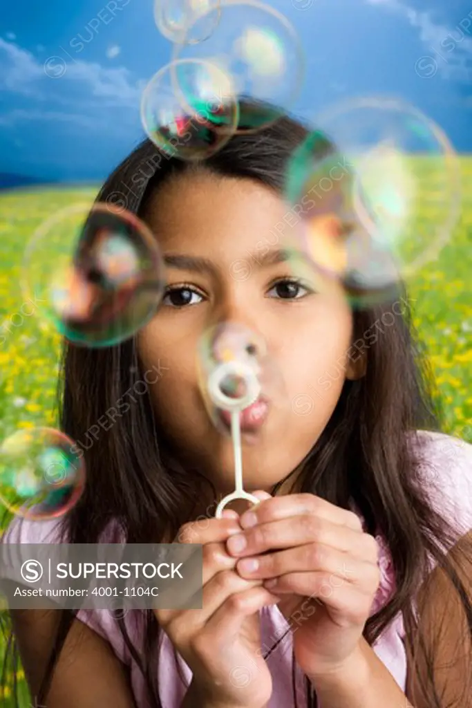 Close-up of a girl blowing soap bubbles
