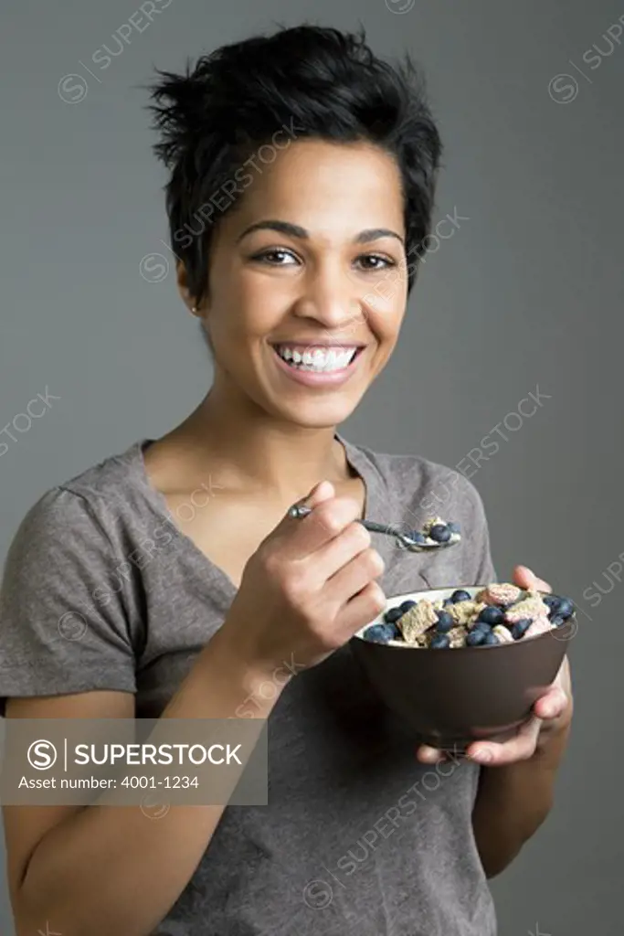 Mid adult woman eating fruit salad