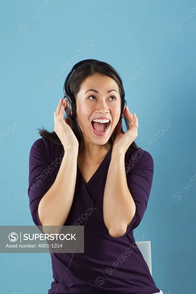 Young woman listening to music with headphones and laughing