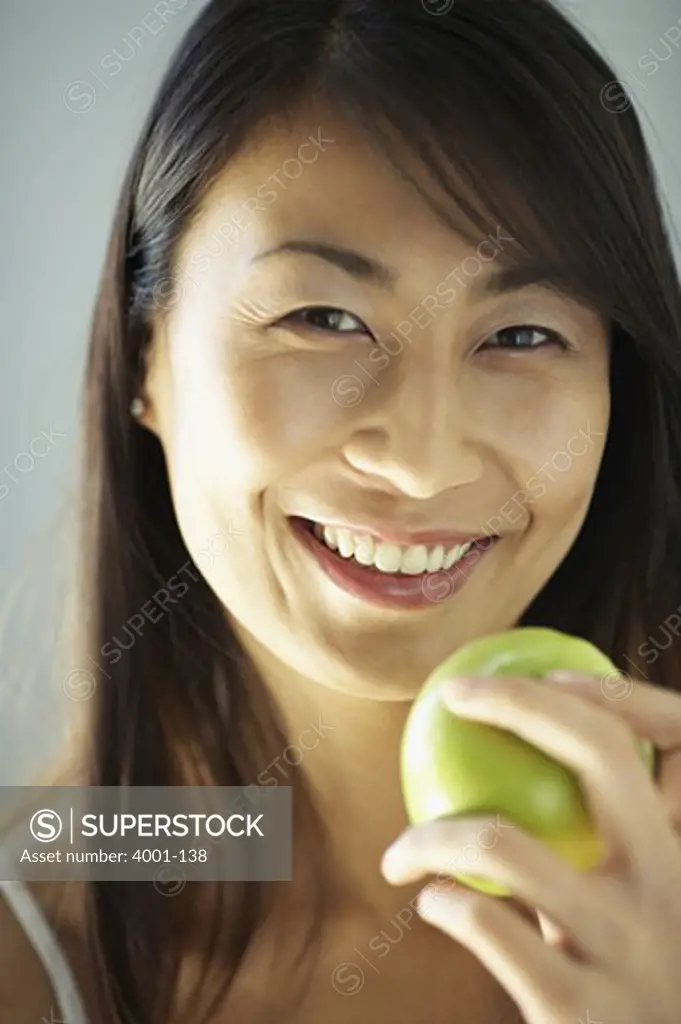 Portrait of a young woman eating an apple