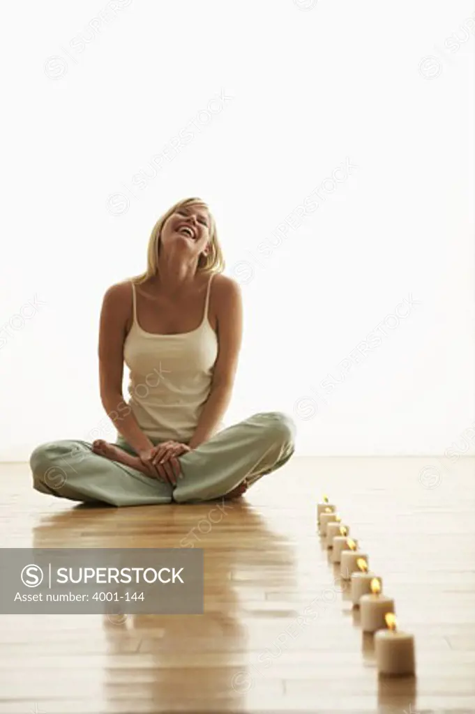 Young woman sitting in front of a row of candles