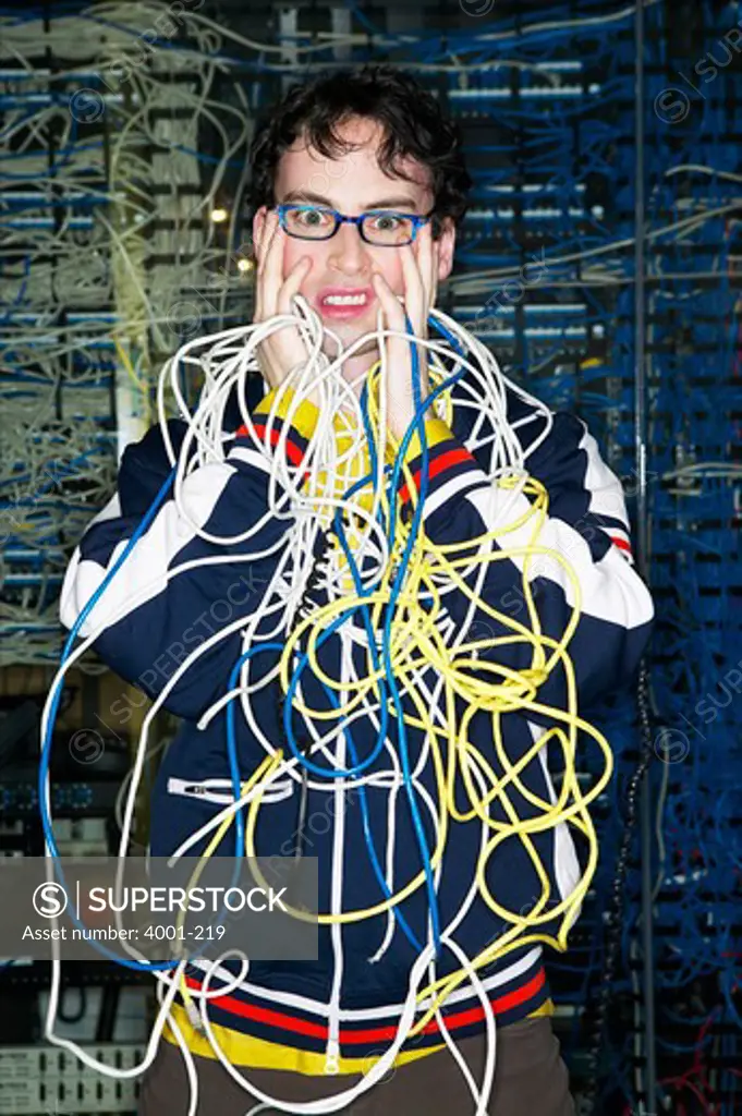 Portrait of a technician tangled in computer cables