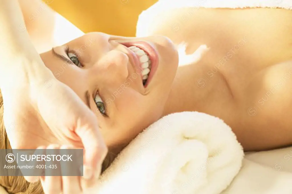 Portrait of a young woman lying on a massage table and smiling