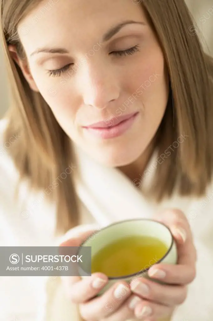 Young woman holding a cup of green tea