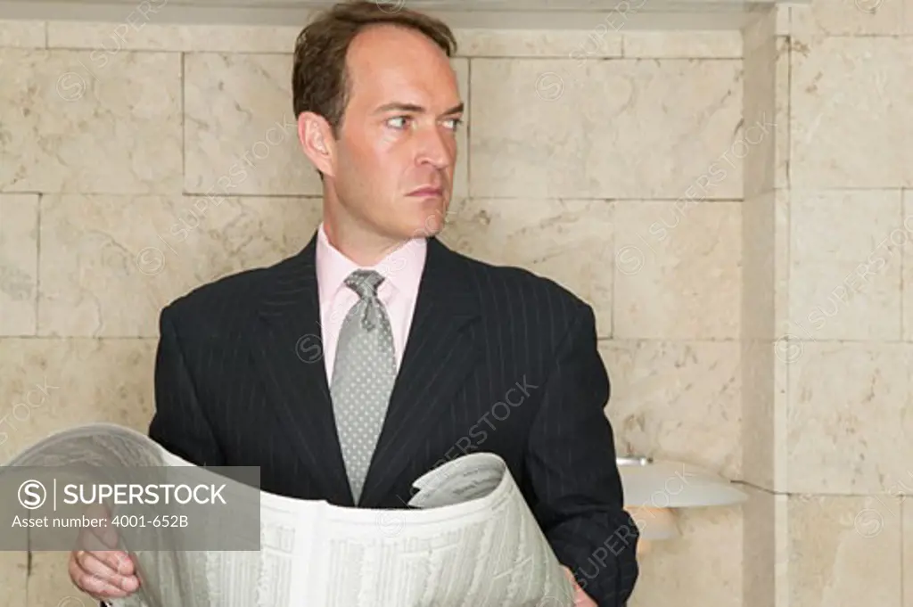 Businessman reading a newspaper in a hotel lobby