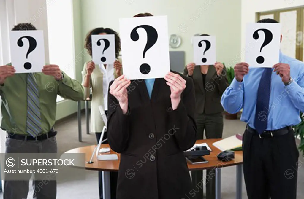 Business executives holding question mark cards in front their faces