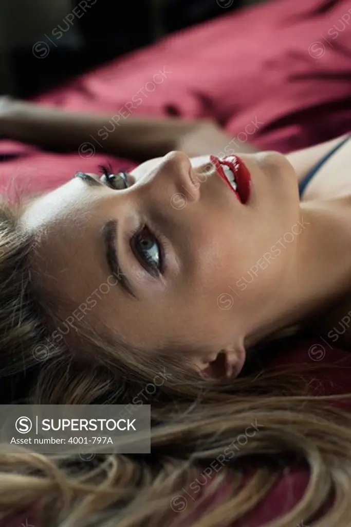 Young woman lying on the bed and day dreaming