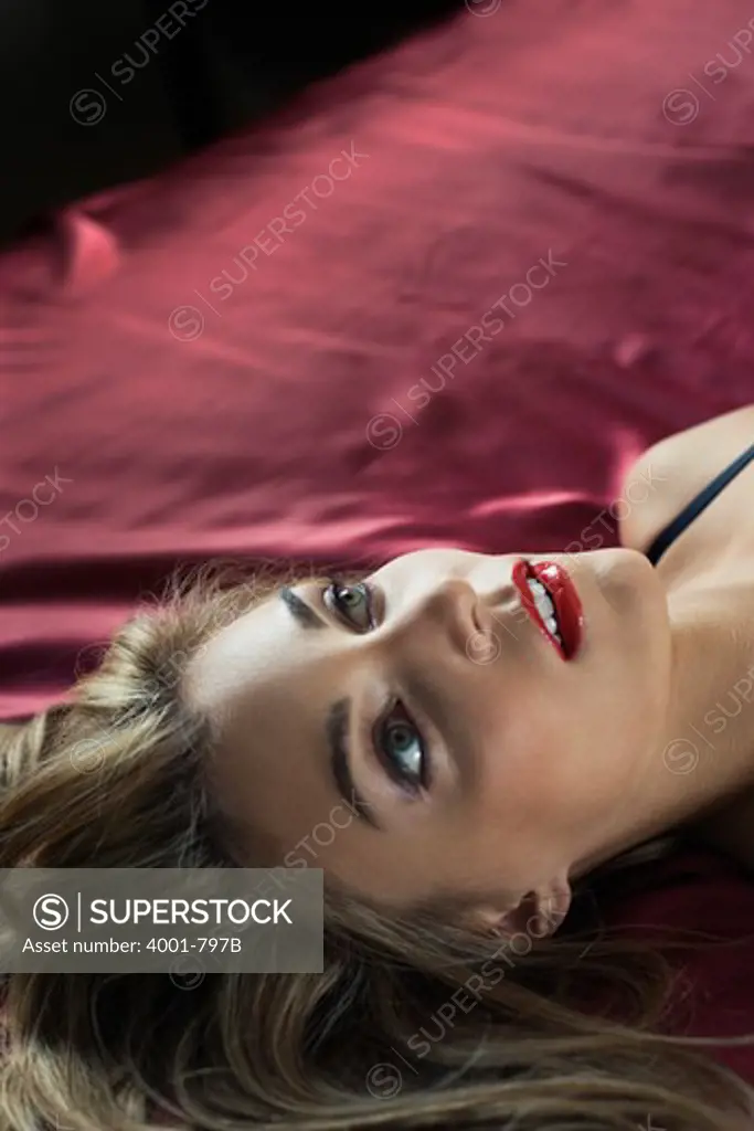 Young woman lying on the bed and day dreaming