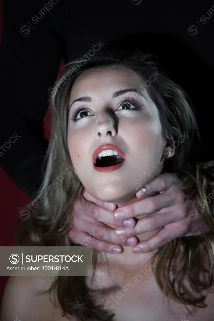 Man's hands strangling a young woman