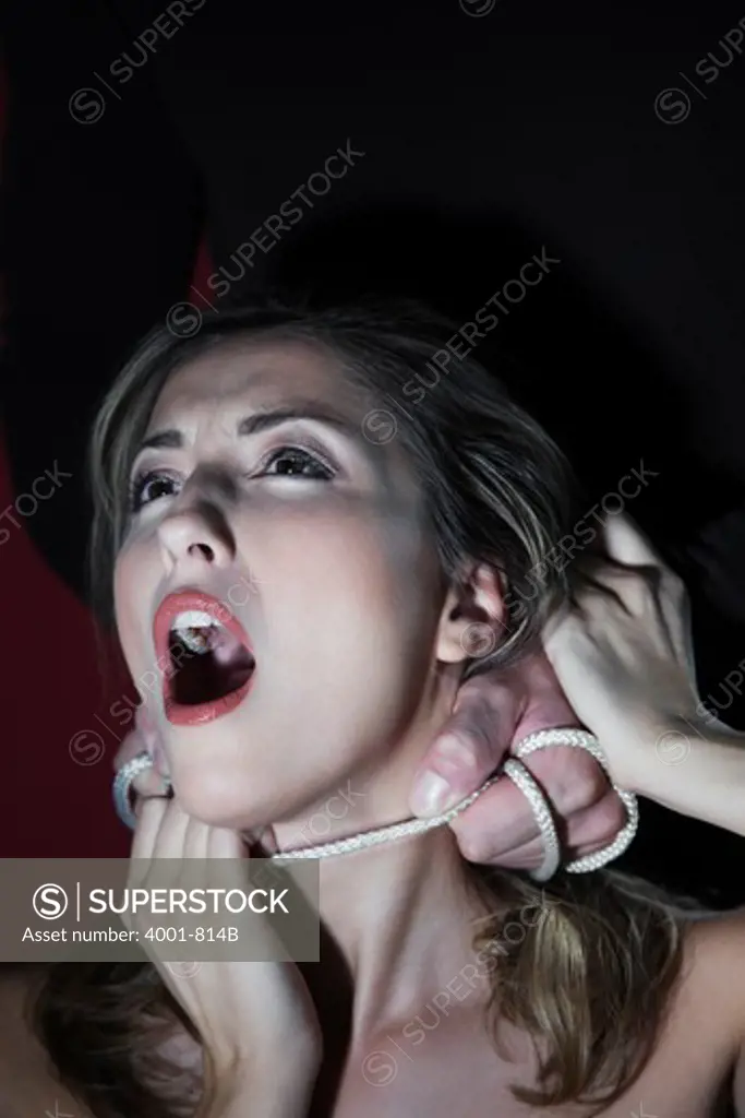 Man's hands strangling a young woman