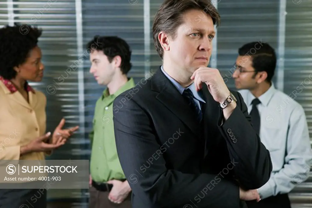 Businessman thinking while meeting goes on in the background
