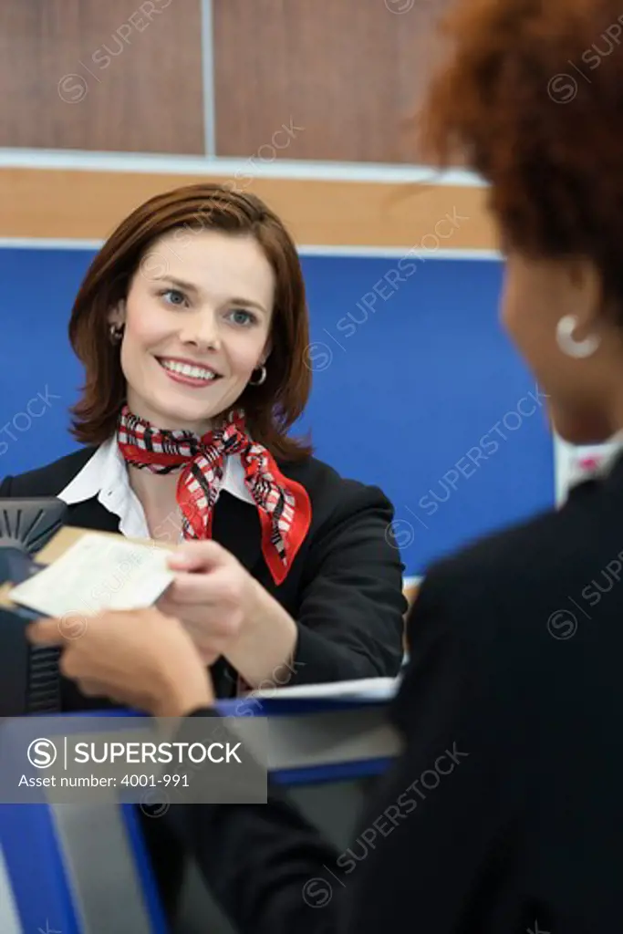 Businesspeople checking in at airport ticket counter
