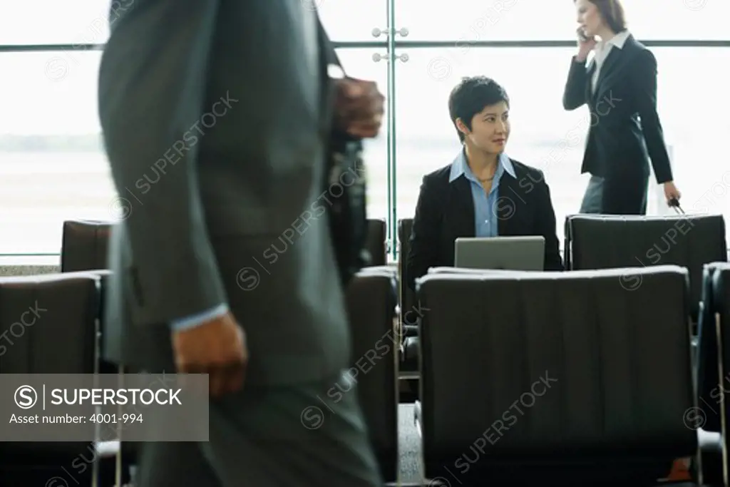 Businesswoman checking in at automated airport ticket counter