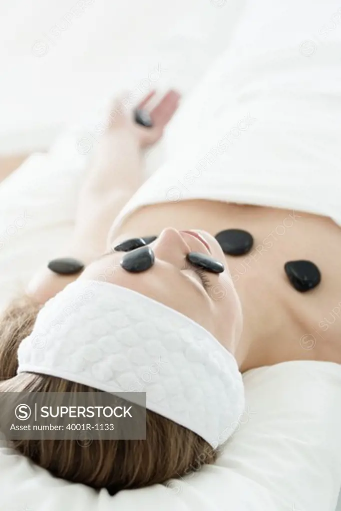 Young woman having stone treatment at spa