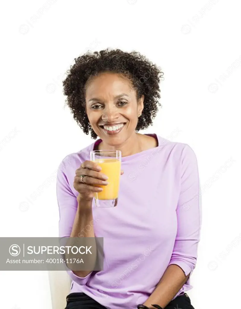 Portrait of a mid adult woman holding a glass of orange juice
