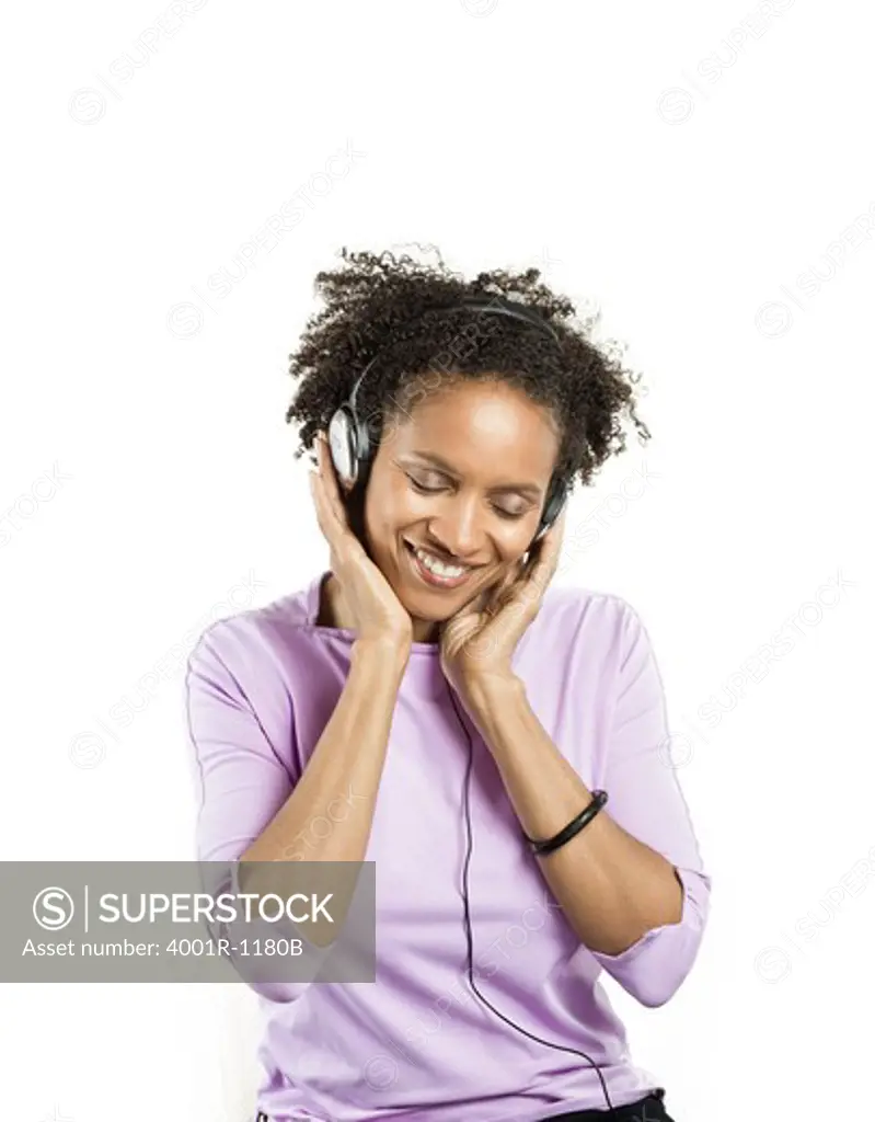 Mid adult woman listening to music with headphones