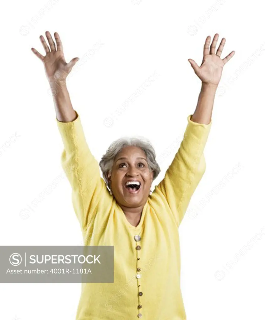 Senior woman standing with her arms raised and looking excited
