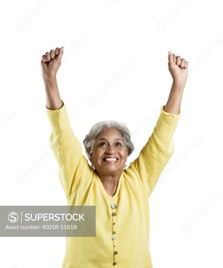 Senior woman standing with her arms raised and looking excited