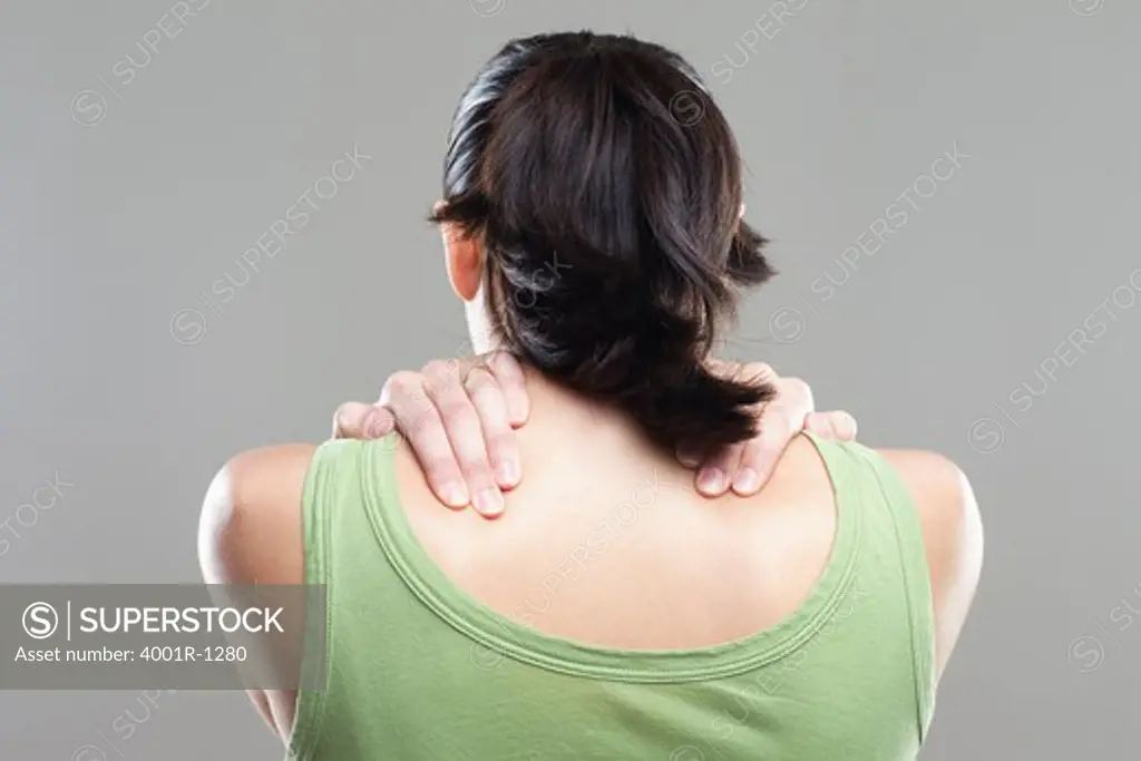 Rear view of a young woman suffering from neckache