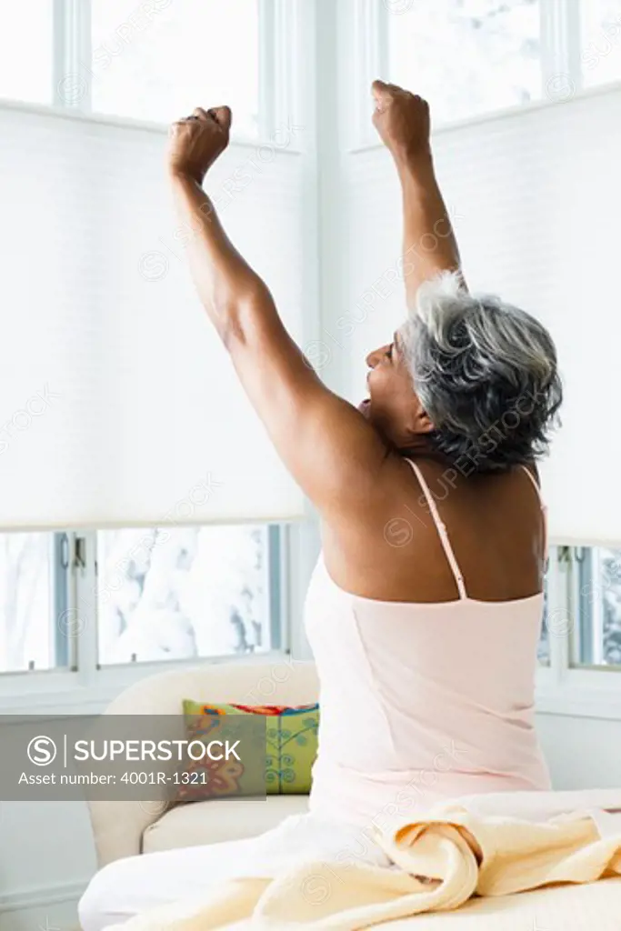 Senior woman stretching on the bed